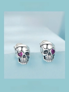 Detail view of 925 sterling silver skull stud earrings with purple heart gemstone