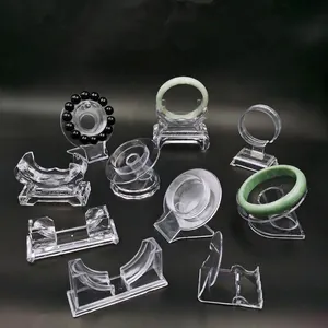 Clear acrylic jewelry stands for bracelets and jade bangles set on black background