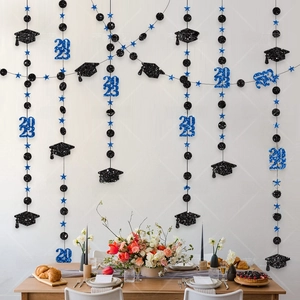 Detail of graduation party hanging decor with black mortarboard and blue 2023 stars