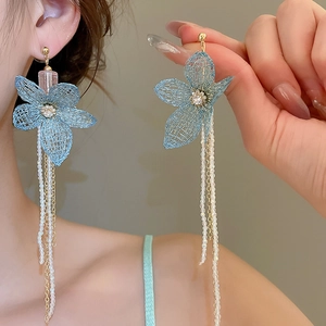 Close-up of blue mesh flower earrings with elegant long pearl tassel drop details