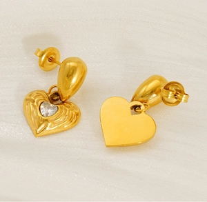 Detailed macro view showing the textured hammered gold heart earrings with zircon inlay