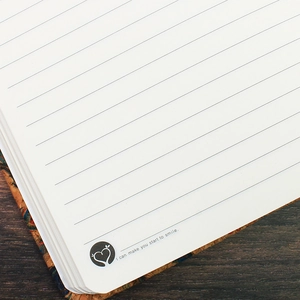 A5 cork cover notebook with lined cream pages and inspirational quote on wooden desk