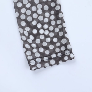 Detailed close-up of the mesh fabric texture and polka dot print with fine stitching