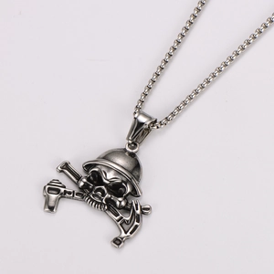 Detailed close-up of a silver skull and hammer pendant on a stainless steel chain
