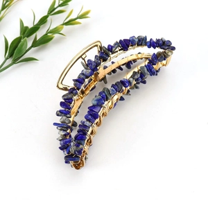 Detailed macro view of handmade golden hair claw clip with blue lapis lazuli stones