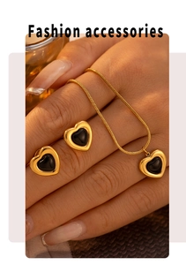 Detail of heart jewelry set with black inlay and golden snake chain on hand