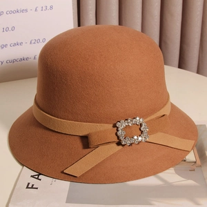 Vue détaillée du chapeau cloche en laine marron avec nœud et boucle en strass brillant
