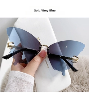 Detail of butterfly-shaped rimless sunglasses with gradient lenses and gold metal hinges