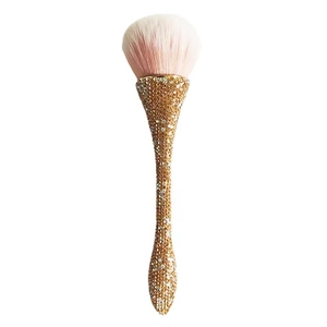 Macro shot of luxury powder brush with pink bristles and gold rhinestone handle