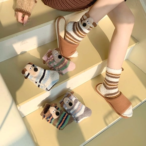 Detail of coral fleece striped socks with 3D puppy design and plush texture