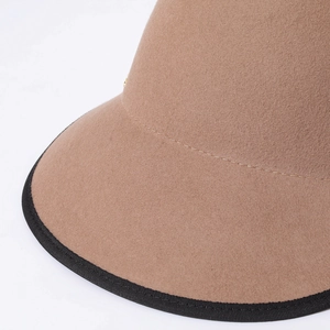 Close-up of camel wool felt hat with black ribbon edge trim and high-quality stitching