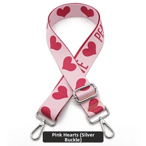 Detail of adjustable pink bag strap with red hearts, PEACE text, and silver hooks