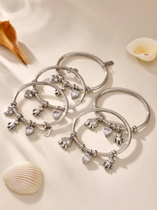 Detailed view of silver stainless steel charm bracelet with bear and heart pendants
