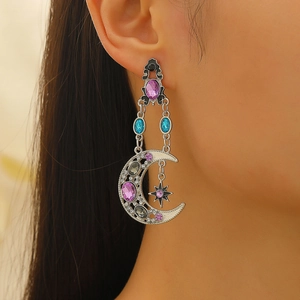 Macro side view of baroque sun and moon earrings with purple and blue crystals