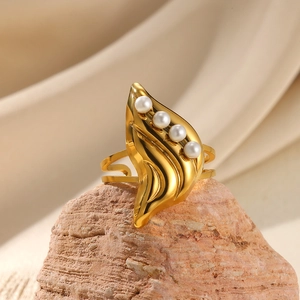 Detail of gold leaf ring with four white pearls placed on a stone and beige silk