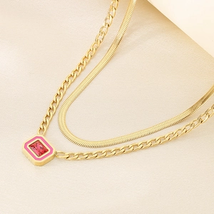 Detail of double-layer gold snake chain necklace with pink square geometric pendant