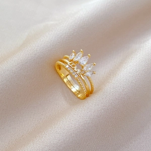 Close-up of golden crown ring with sparkling rhinestones and LOVE engraving on satin