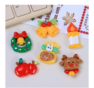 Flat lay of resin Christmas DIY charms including wreath, bell, candle, apple, and reindeer
