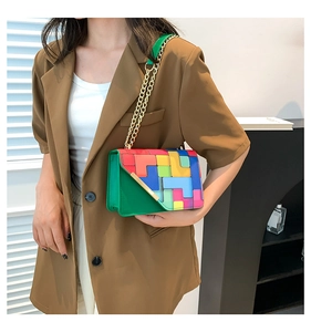 Detail view of colorful geometric patchwork crossbody bag with golden chain strap