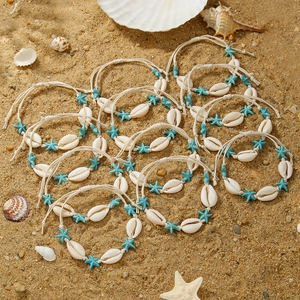 Detailed view of handmade bohemian beach bracelets with natural shells and starfish charms