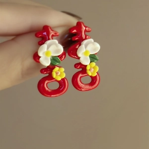 Traditional red Xi character flower stud earrings in hand-held display style