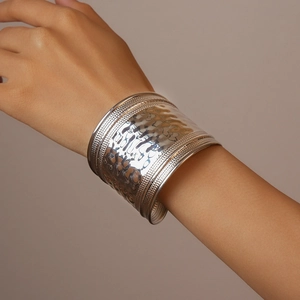 Detail of silver wavy hammered texture and dotted edges on a wide open cuff bracelet