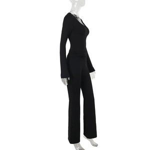 Detail view of black slim fit long sleeve jumpsuit with flared legs and lace V-neckline
