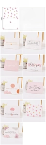 Detail of minimalist greeting cards featuring soft pink floral designs and inspiring quotes