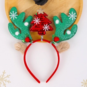 Detail of Christmas reindeer antler headband with a red sequin tree and holly berry decor
