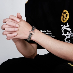 Detailed view of vintage dragon head bracelet in polished steel on male model wrist