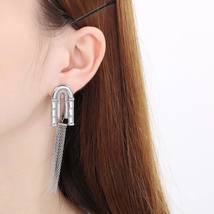 Gros plan de longues boucles d'oreilles à franges argentées portées par un mannequin