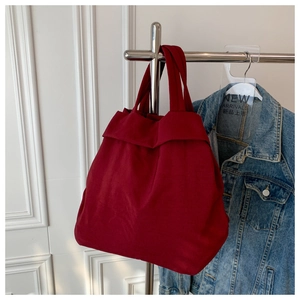 Detail of red oversized nylon tote bag hanging on a rack for casual daily use