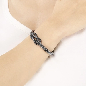 Detailed macro view of silver knotted industrial style bracelet on a model wrist