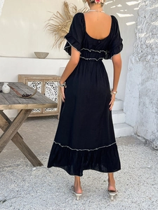 Back view of black bohemian maxi dress featuring ruffled hem and flattering high waistline