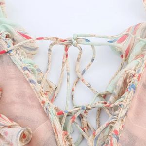 Détail des lacets ajustables sur une robe en mousseline rose à imprimé floral
