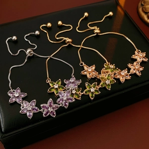 Nahaufnahme von Zirkon-Blumenarmbändern in Gold und Silber mit verstellbarem Verschluss
