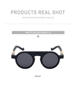 Front view of matte black round sunglasses with gold metal hinges and gray lenses