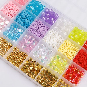 Close-up of a 24-compartment storage box filled with colorful polymer clay beads and charms