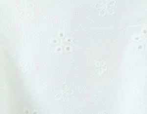 Macro shot of white lace floral embroidery with intricate hollow-out eyelet details