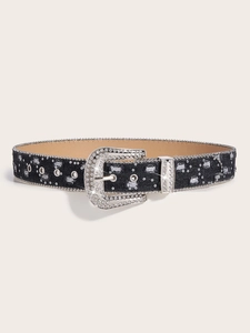 Close-up of denim belt featuring sparkling square rhinestones and horseshoe buckle