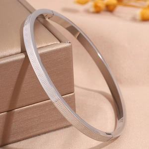 Detail of silver titanium steel bangle with vintage geometric Greek key pattern engraving