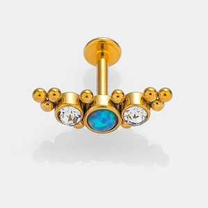 Golden opal labret stud with blue opal and clear zircon stones on grey background