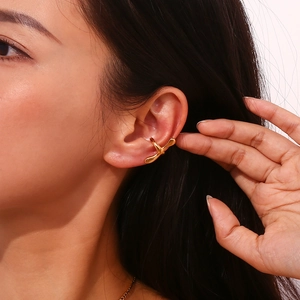 Detailed view of an 18K gold plated liquid metal ear cuff with organic flowing design