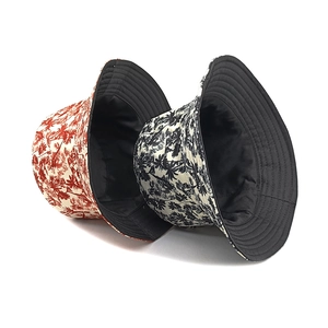 Double-sided bucket hat featuring tropical palm tree prints in red and black patterns
