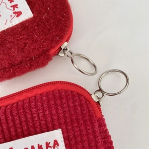 Detail of red plush and corduroy coin purses with zipper and metal ring pulls