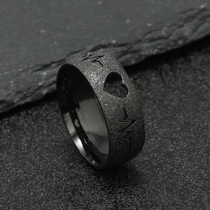 Macro shot of black matte stainless steel ring featuring heart cutout and ECG pulse line