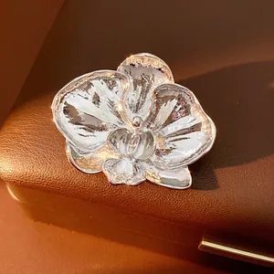 Polished silver orchid flower brooch in metal style on a premium leather jewelry box