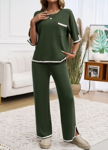 Détail d'un ensemble en maille vert foncé avec liseré blanc sur le haut et le pantalon