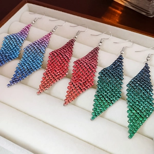 Gros plan de boucles d'oreilles à pompons en strass avec dégradés de couleurs vives