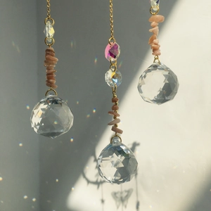 Macro shot of faceted crystal balls and natural pink stones casting rainbow light patterns
